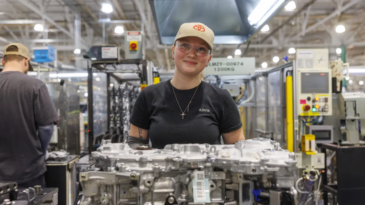 A production worker poses for a photo at a Toyota engine plant.