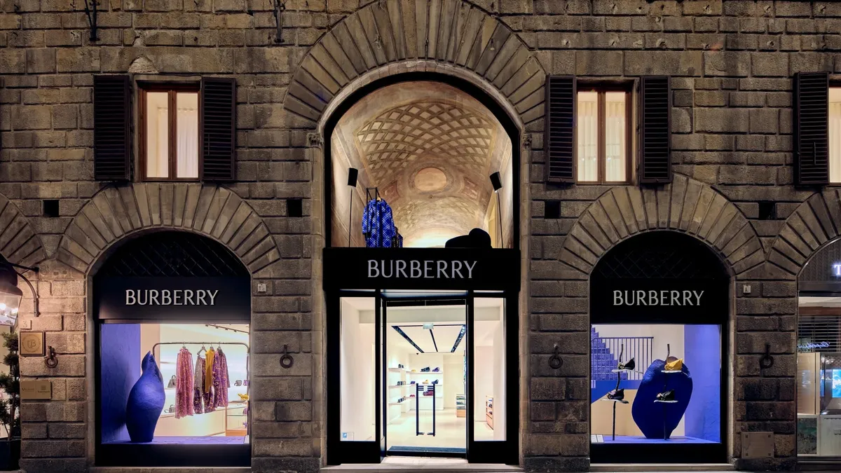 A lit Burberry storefront as seen in the evening on an empty street.