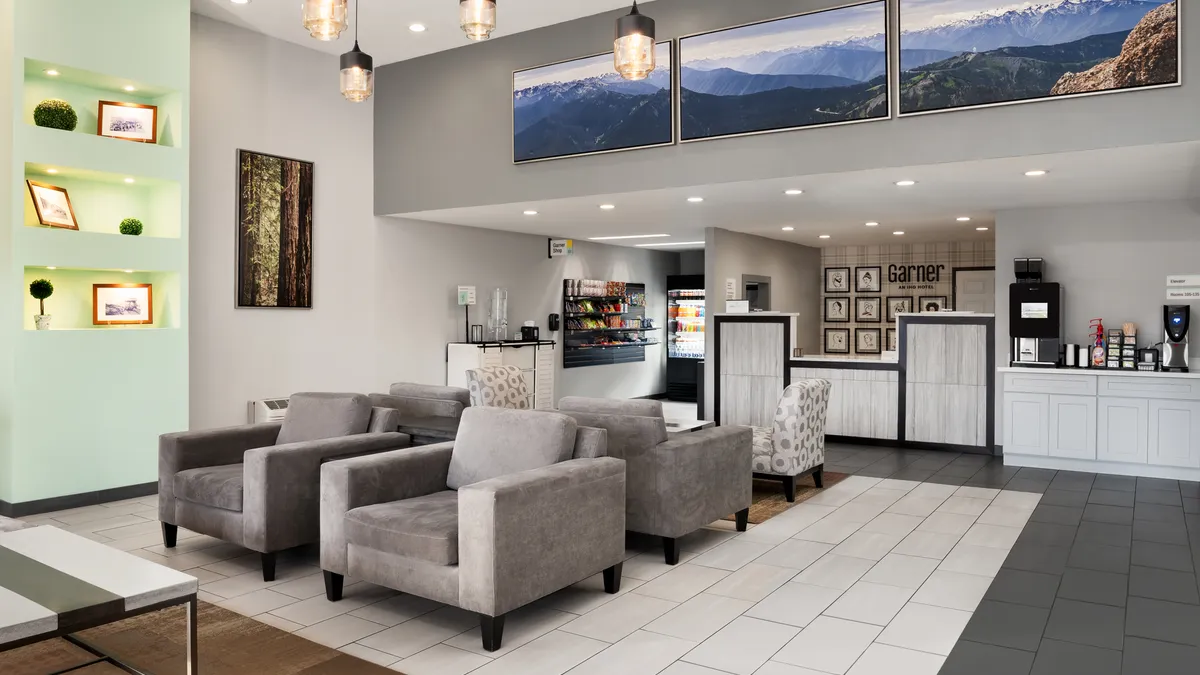 Hotel lobby with gray chairs and a check-in desk.