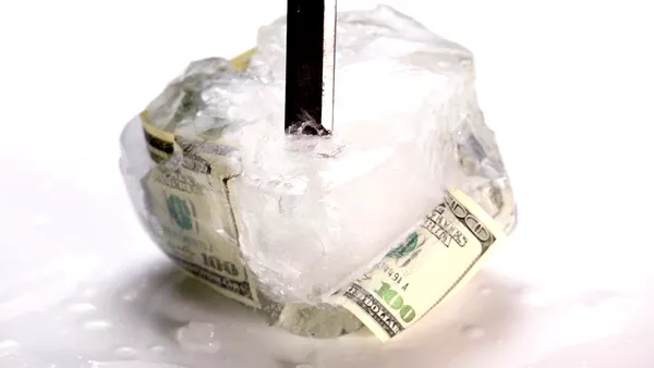 Breaking ice frozen with $100 bill.