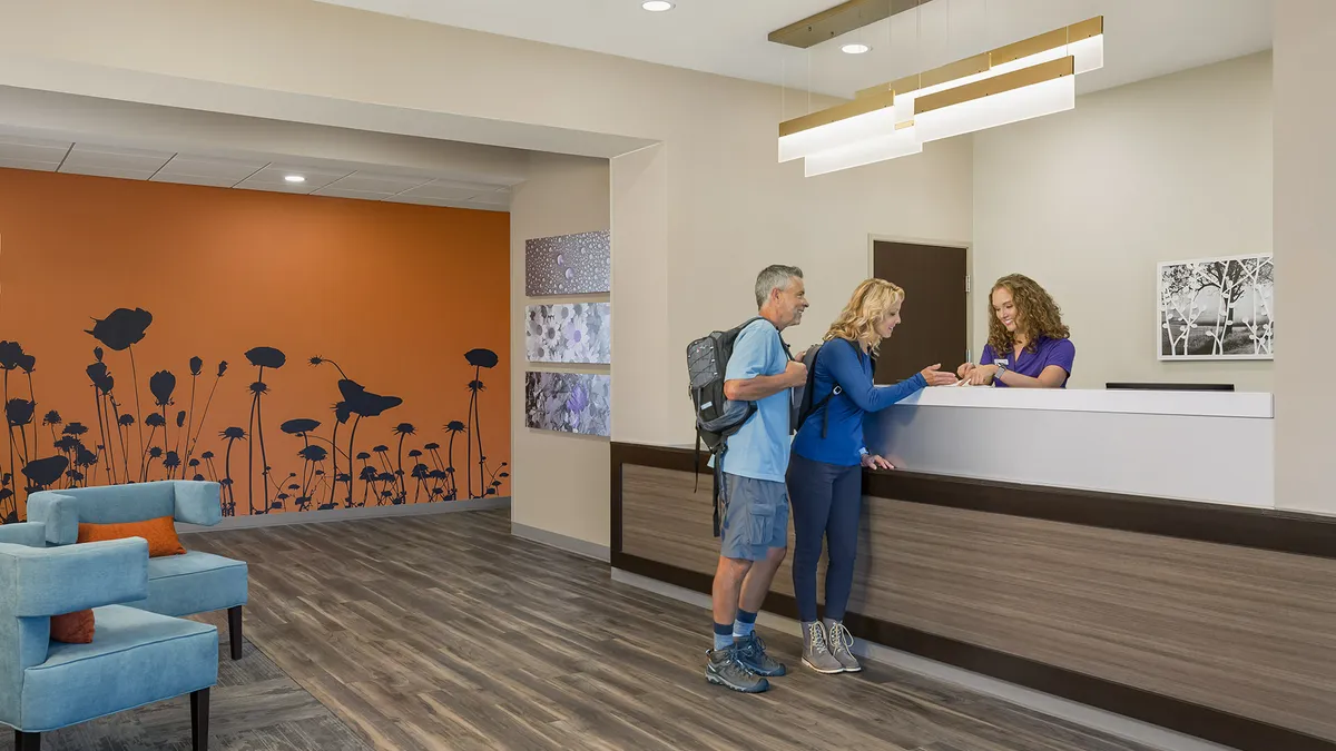 Guests standing at hotel check-in desk