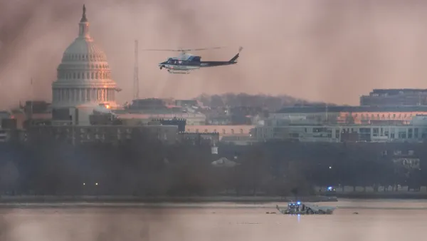 A helicopter flies near the site of the American Airlines plane crash on the Potomac River.