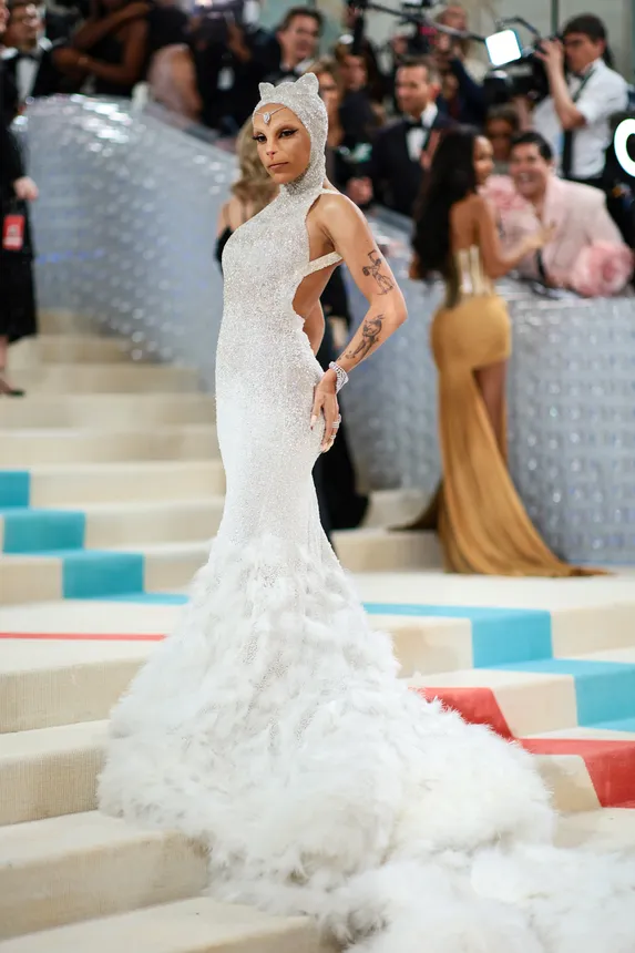 Woman wearing cat prosthetics stands on Met Gala carpet posing