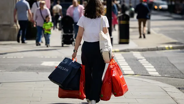 A shopper holds multiple shopping bags.