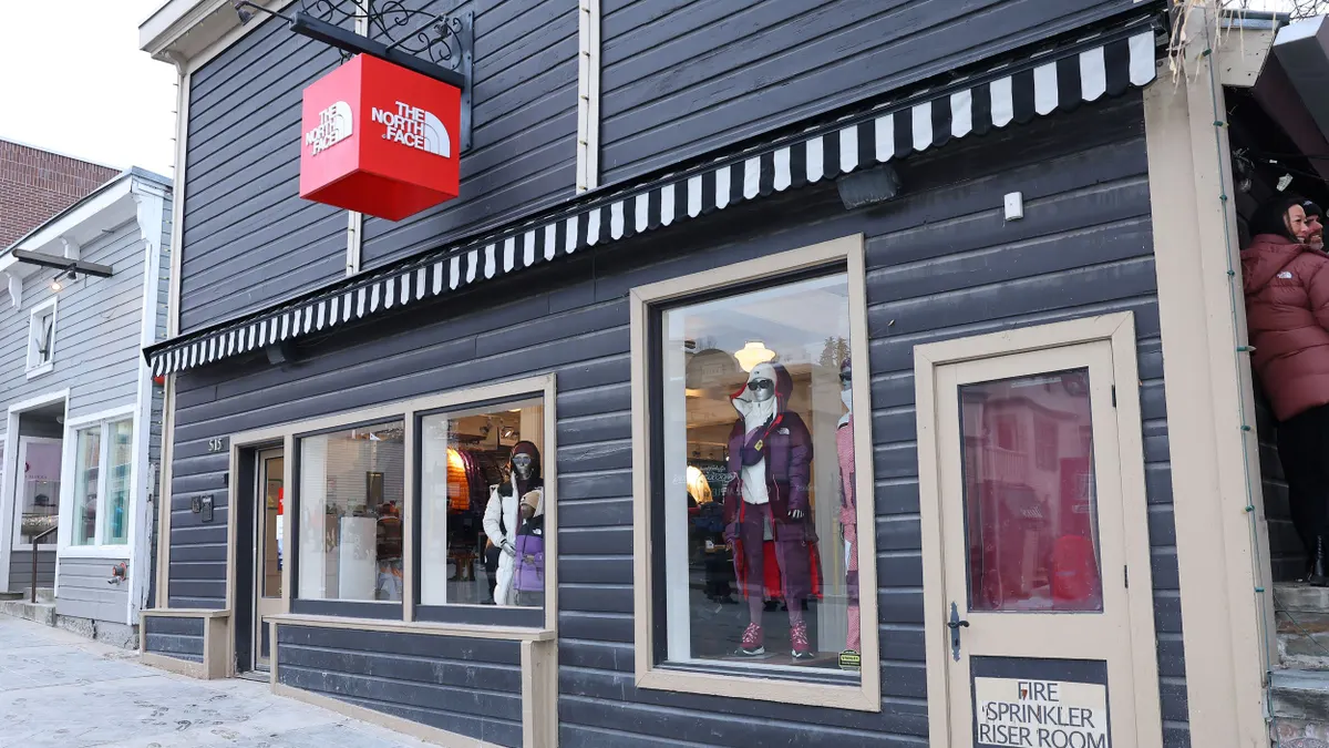 A North Face storefront. The sidewalk in front of it is covered in snow.