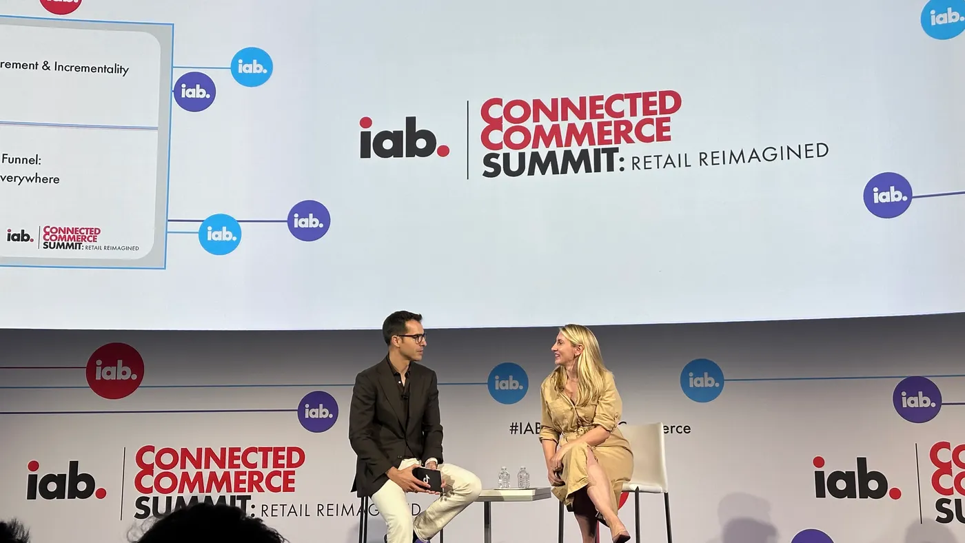 Man and woman sitting next to each other on stage during a panel at IAB's Connected Commerce Summit
