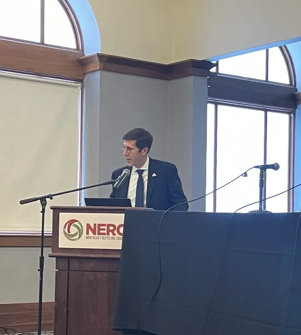 Providence Mayor Brett Smiley speaks at a podium with the NERC logo