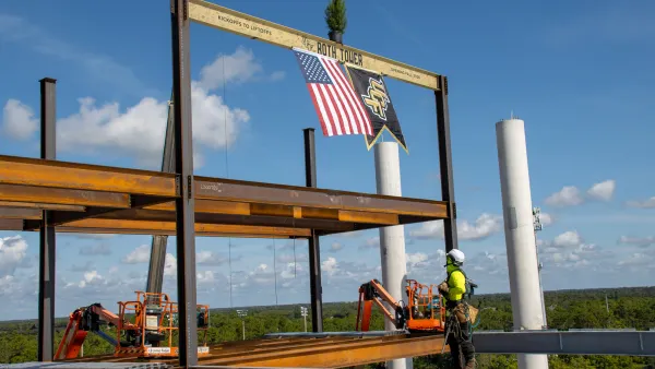 A construction worker on top of a tall construction project.