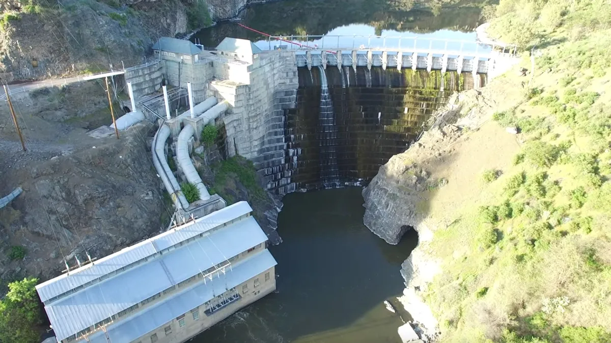 Aerial view of a tall dam on a river.