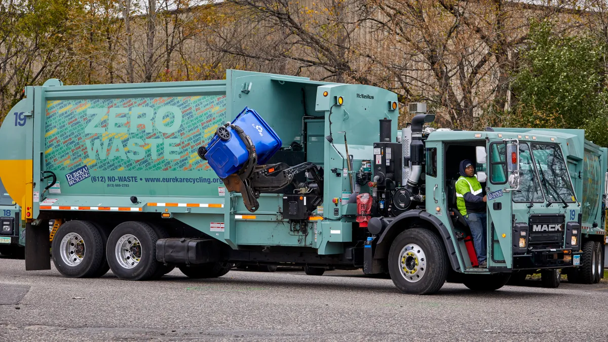 An automated side arm on a Eureka Recycling truck dumps recycling into the truck