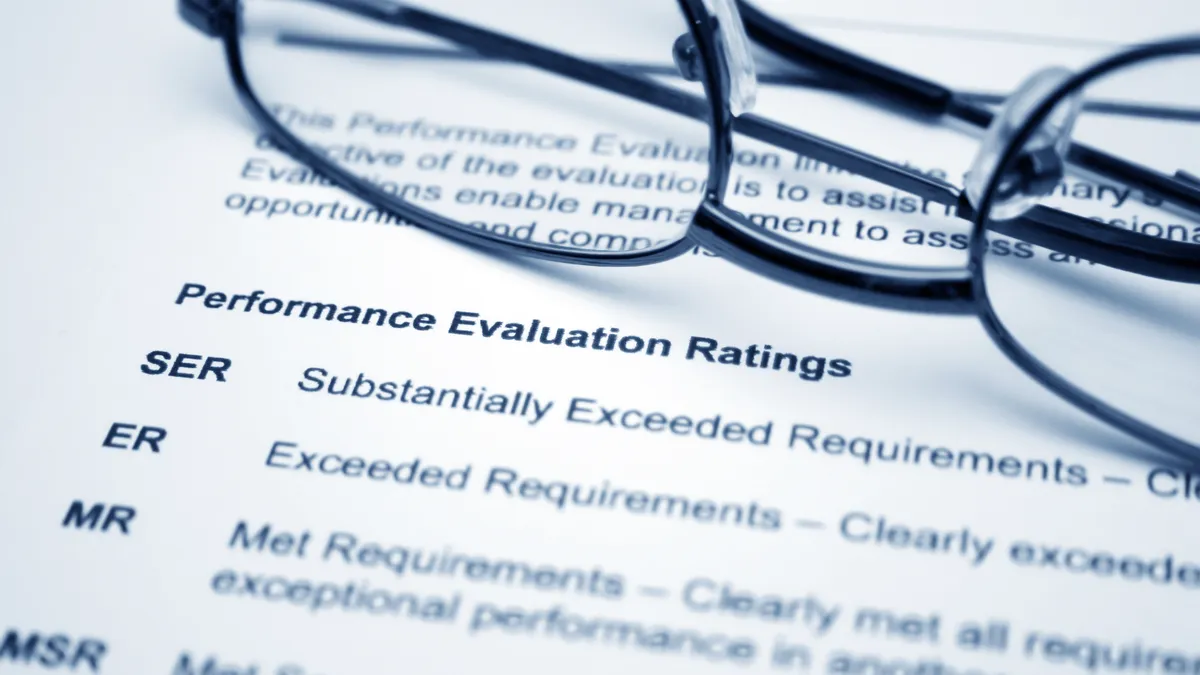 A paper with job performance metrics on it, with glasses folded at the top