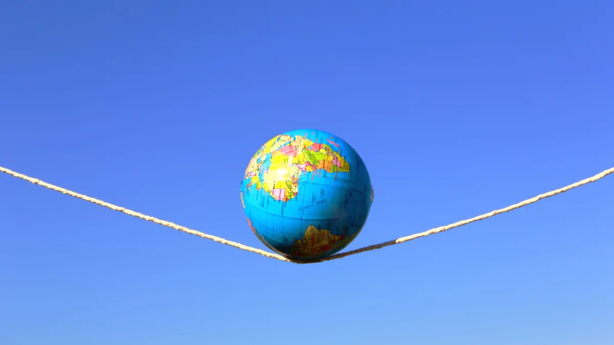 Earth globe on a stretched rope over a blue sky