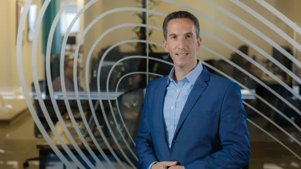 Phil Goldfeder stands in front of a glass wall.