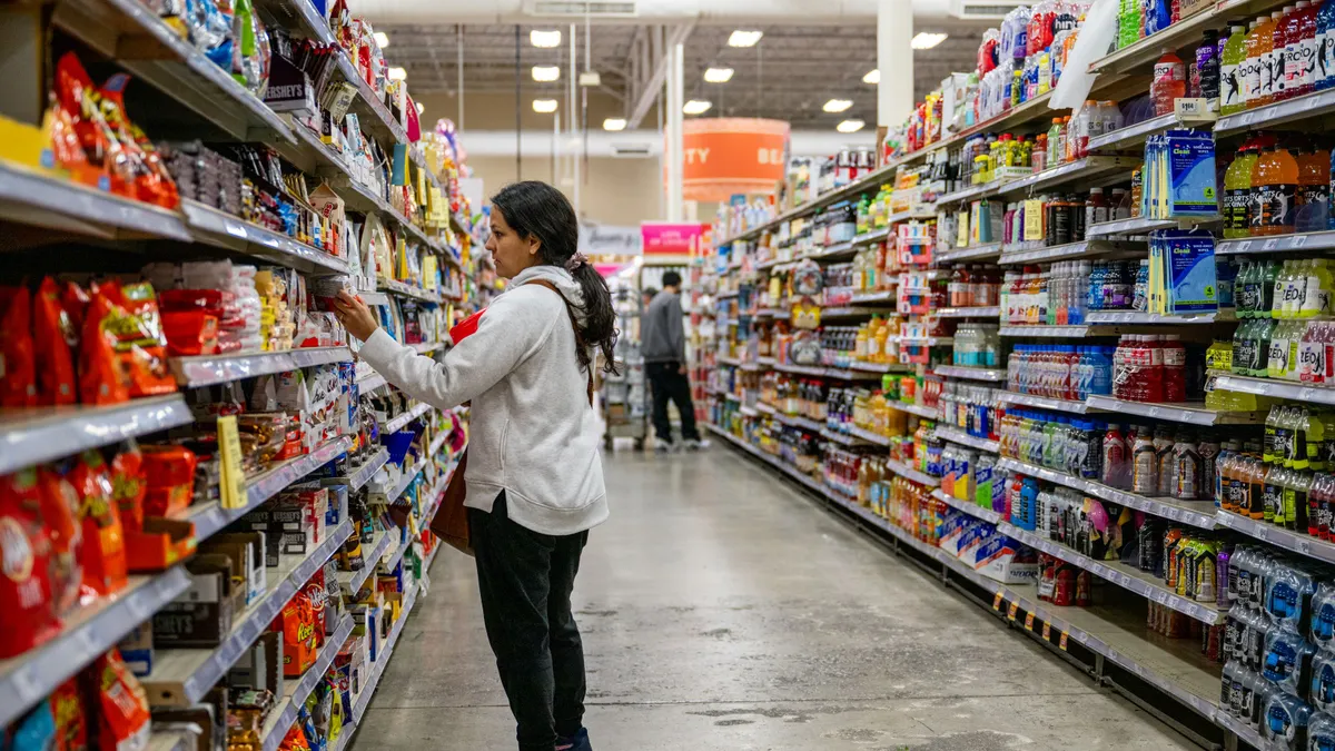 A customer examines a product in a grocery aisle.