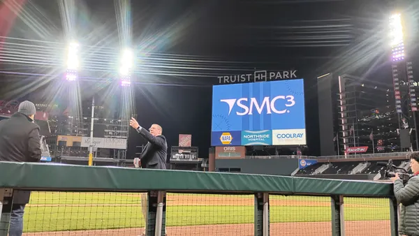 An SMC3 JumpStart attendee takes a selfie on the field of Truist Park.
