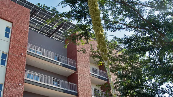 An apartment building with solar panels on the roof.
