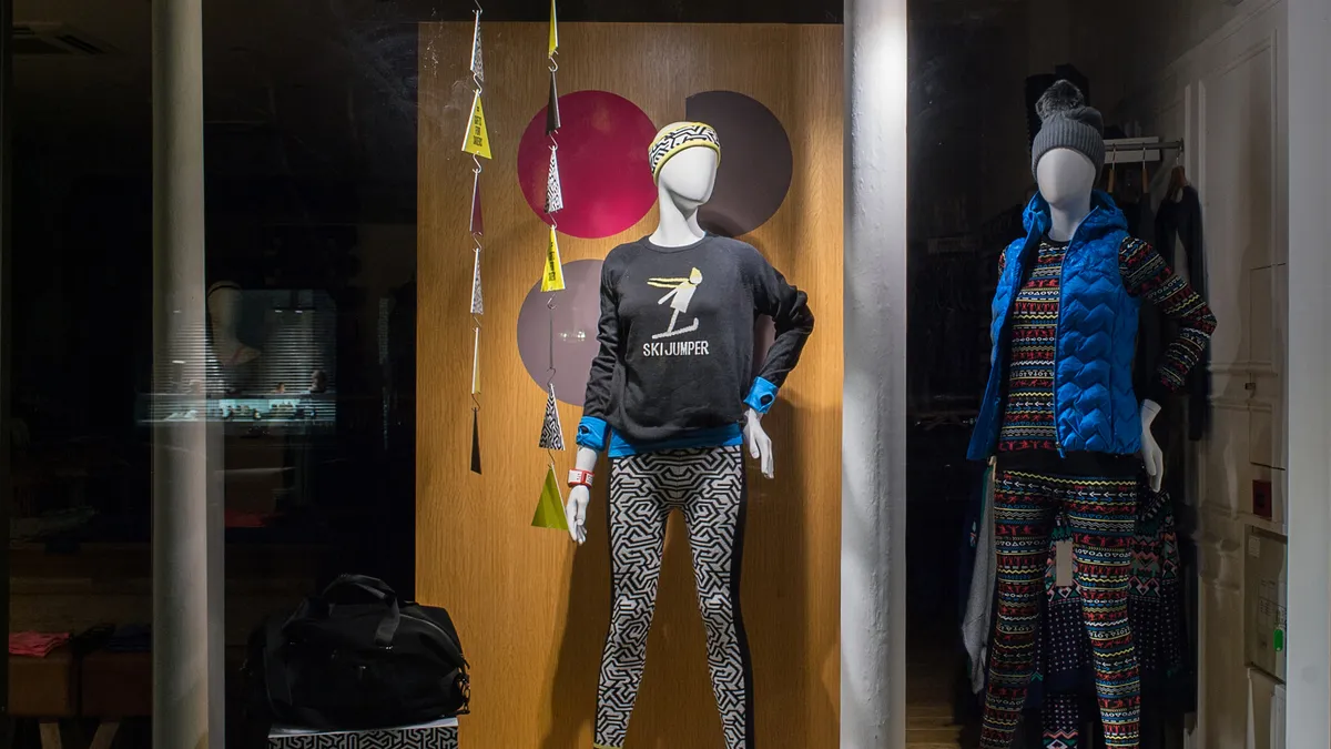 Two mannequins are seen on display in a Sweaty Betty store window.