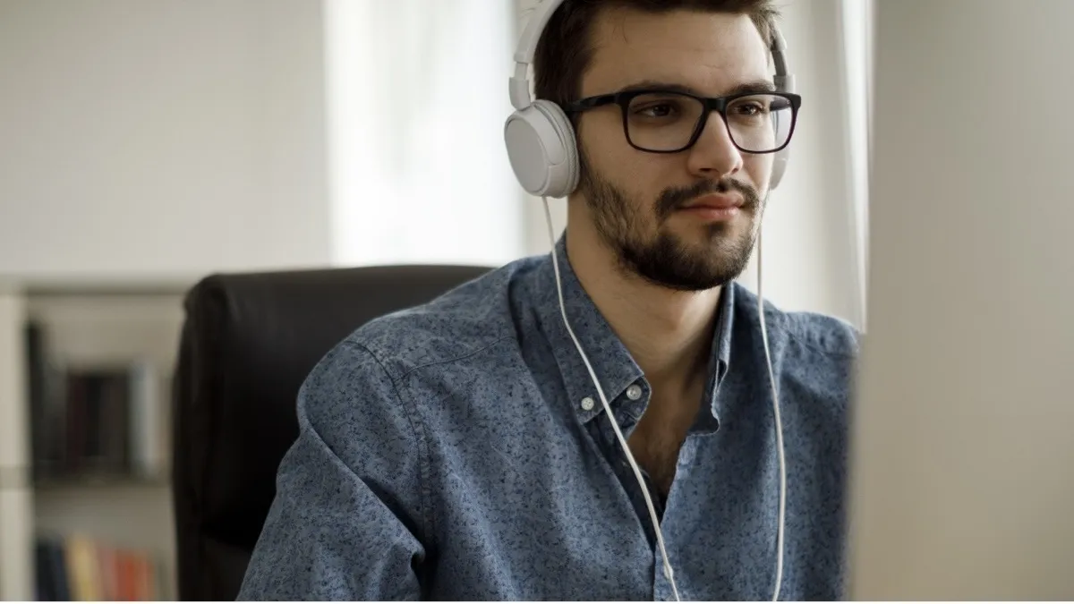 Man wearing headphones infront of monitor