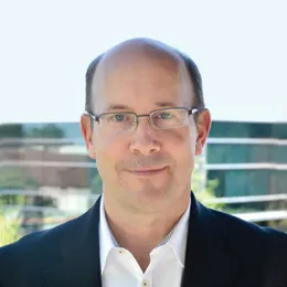 A headshot of Troy Wilson, CEO of Kura Oncology.