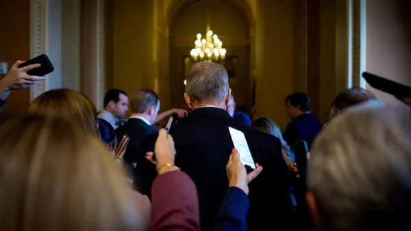 Senate Leader John Thune seen from behind as he speaks to reporters