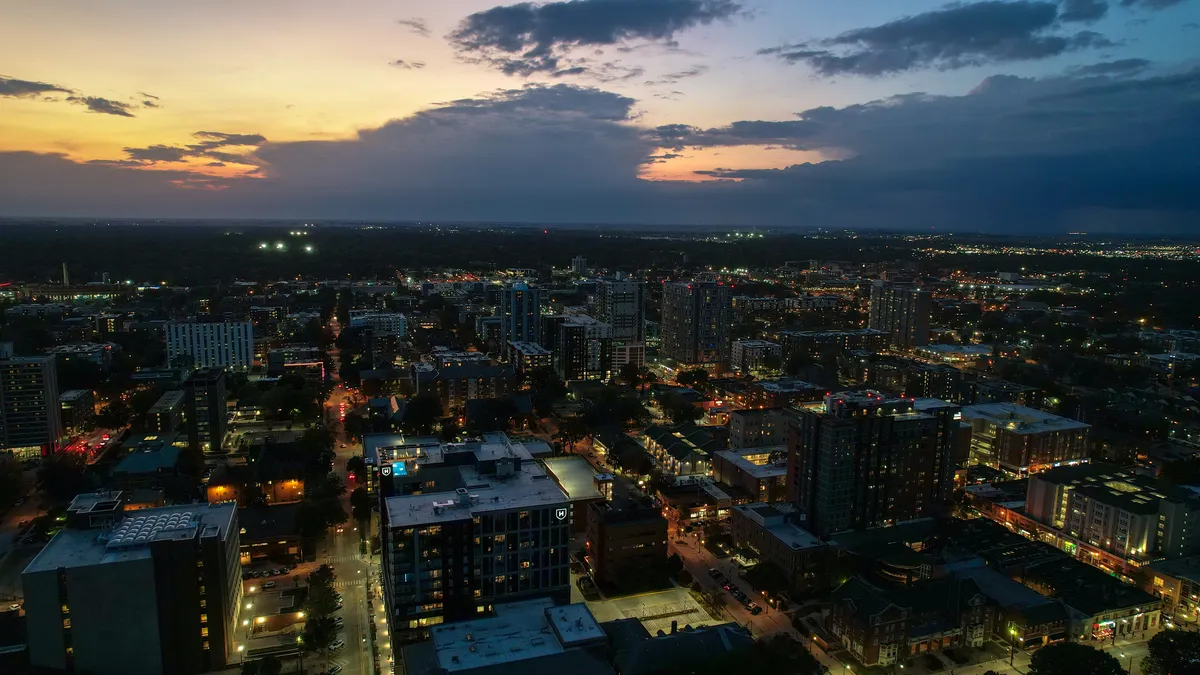 High angle view of illuminated city against sky at sunset.