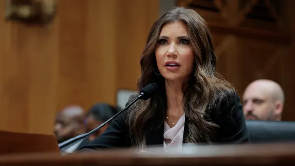 A woman speaks into a microphone during a hearing in front of Congress.