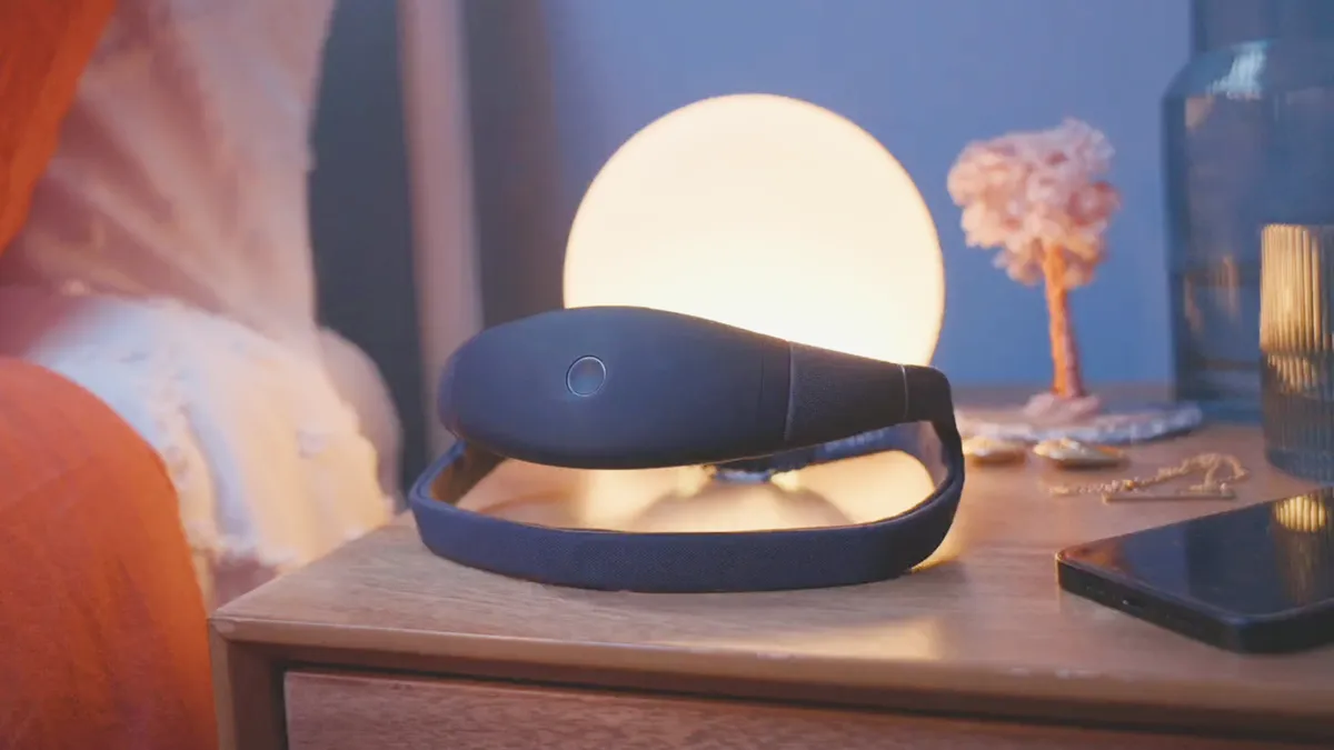 A headband sits on a nightstand in front of a lamp