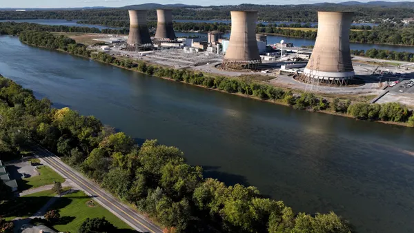 An aerial view of a nuclear power plant's cooling towers on an island in the middle of a river.