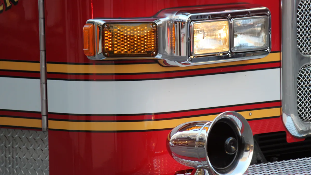 A close-up view of the front end of a red fire truck.