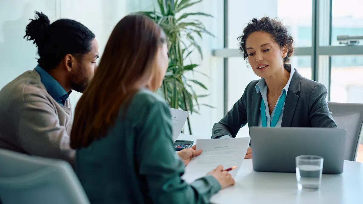 Financial advisor and her clients analyzing documents during a meeting