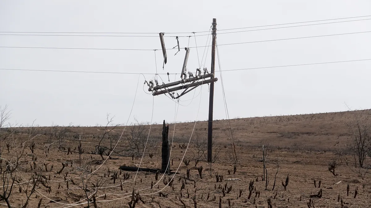 The remains of a charred power pole hangs from power lines in the aftermath of the Smokehouse Creek fire on March 03, 2024 near Canadian, Texas.