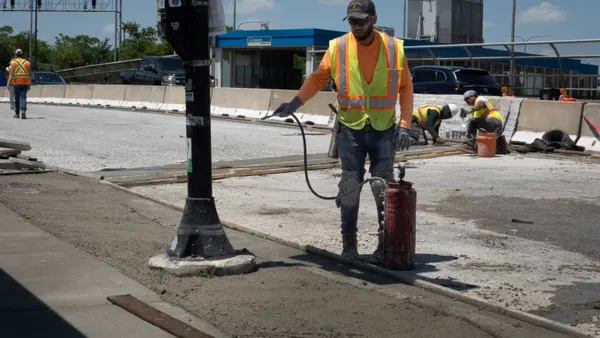 A construction worker wets concrete
