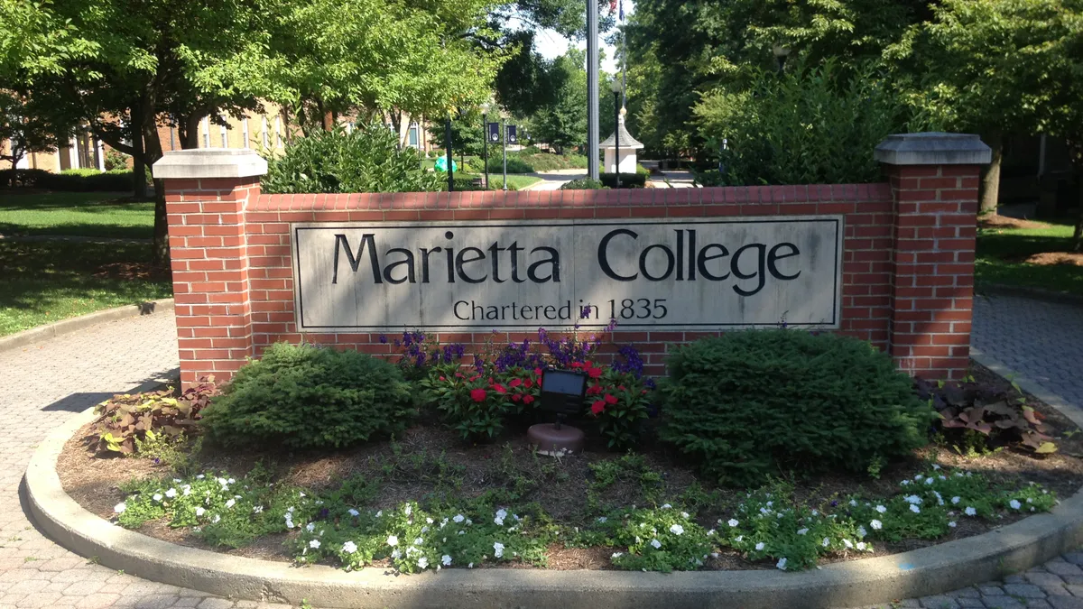 An campus entry sign made of brick that reads "Marietta College, chartered in 1835"