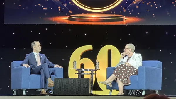 Nicholas Kent speaks on stage with NASFAA President Melanie Storey.
