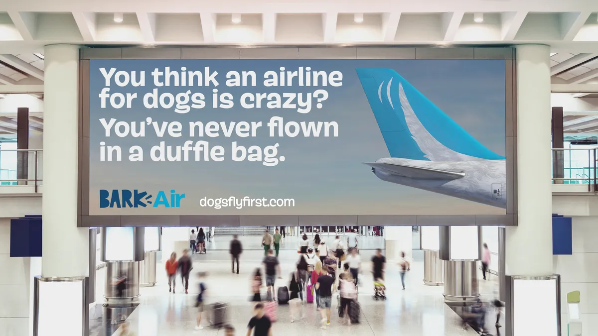 A billboard with an airplane and the words, "You think an airline for dogs is crazy? You've never flown in a duffle bag."