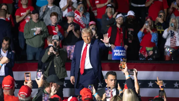 Former President Donald Trump waves to guests, who were standing and clapping, as he left a campaign rally in Grand Rapids, Michigan.