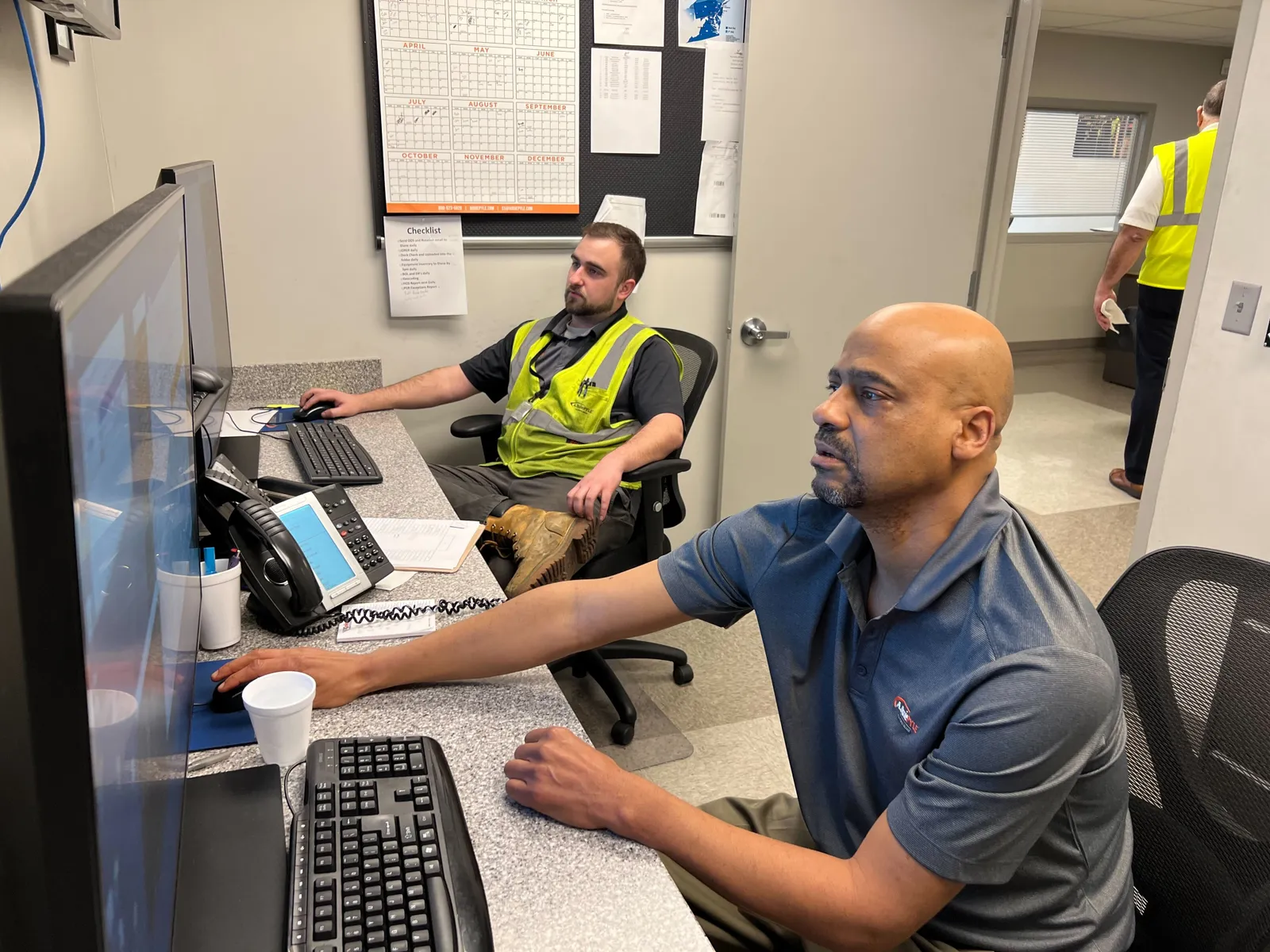 A. Duie Pyle dispatchers Cole Digney and Gregg Gregory, right, are responsible for planning drivers' routes and coordinating additional pickups and deliveries, respectively.