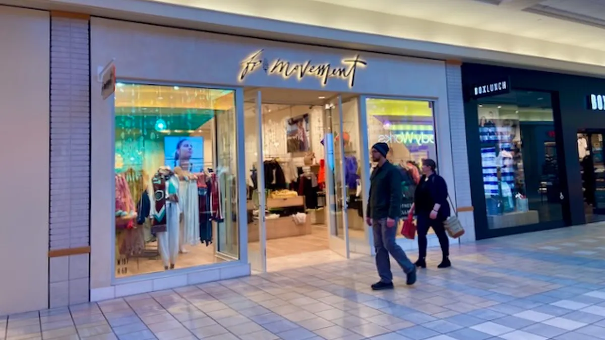People walking past a mall store.