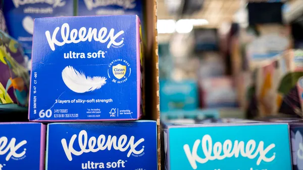 Boxes of Kleenex-brand tissues stacked on a store shelf. One group of boxes are labeled "Kleenex ultra soft" and another is labeled "Kleenex cooling + aloe."