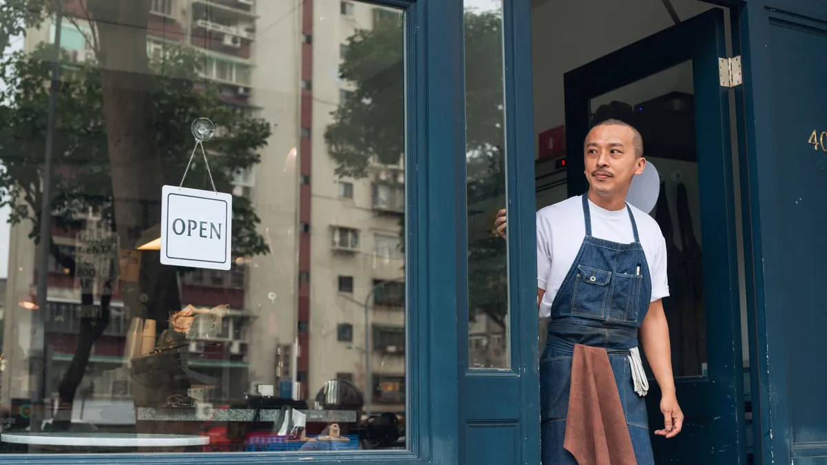 Coffee shop owner with Open sign