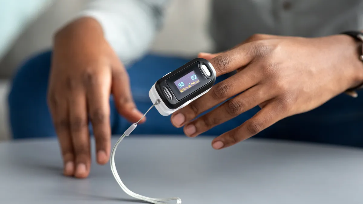 A man using an at-home pulse oximeter.