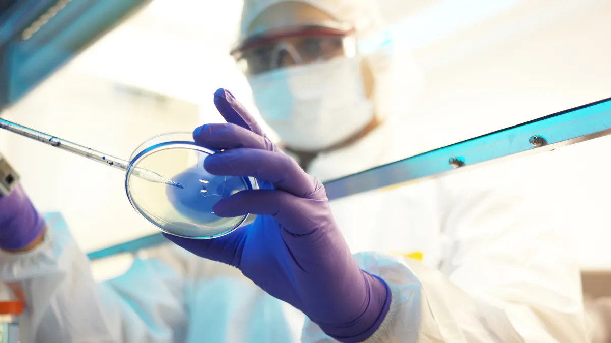 A laboratory technician conducts an experiment in a clean room.