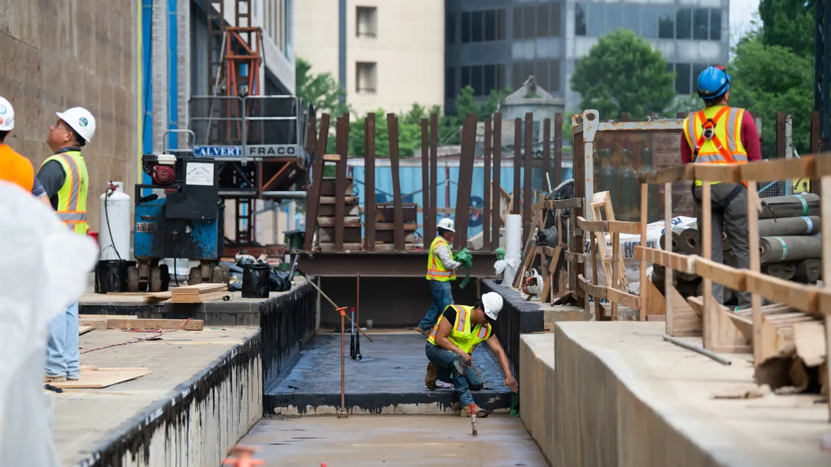 Construction workers complete tasks on a jobsite.