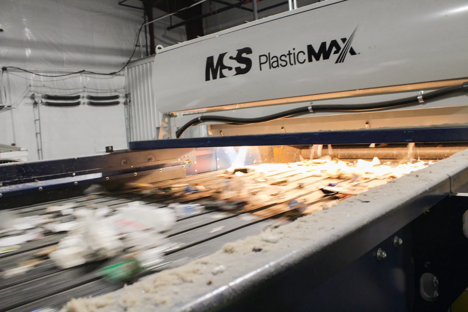 A piece of equipment uses light and air to sort plastic from other recyclable materials.