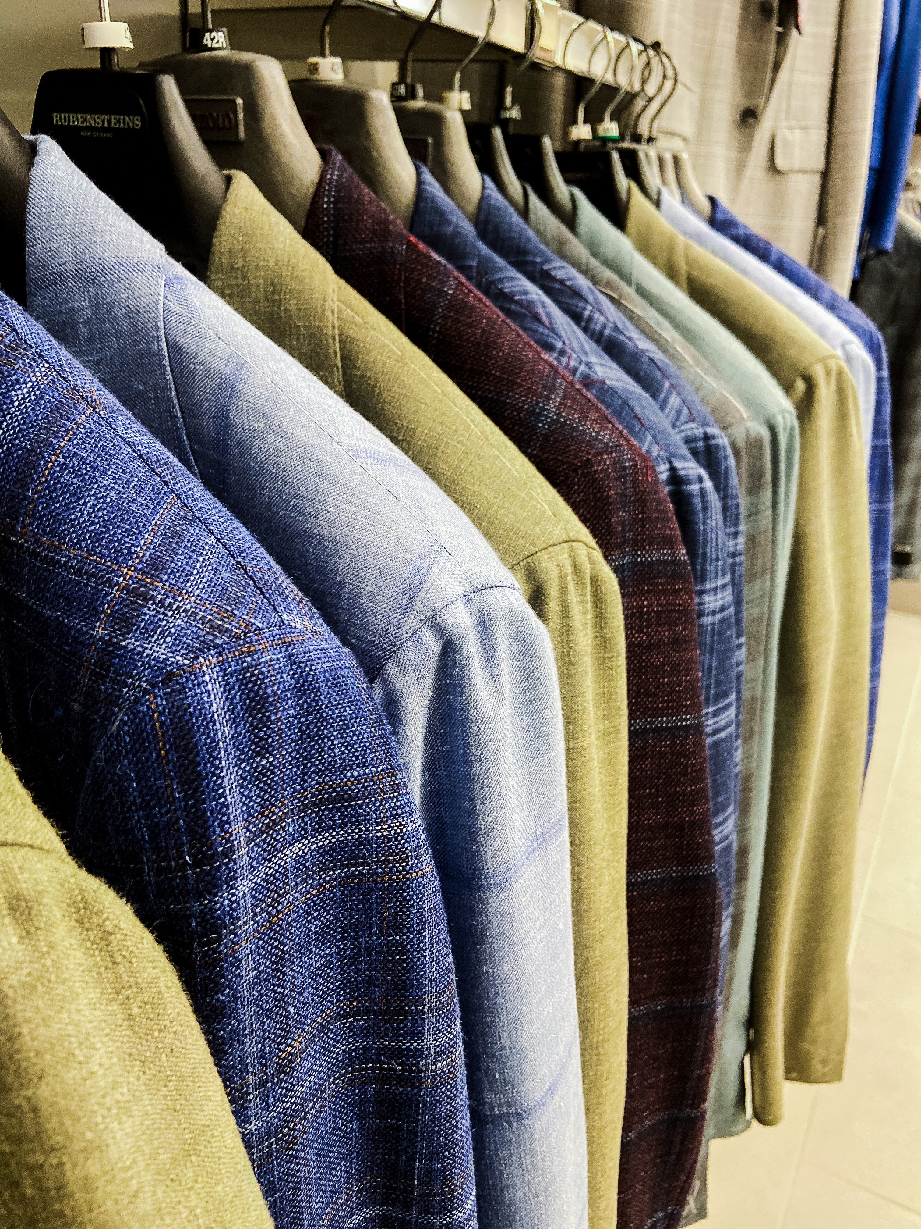 A row of jackets in various colors on hangers.