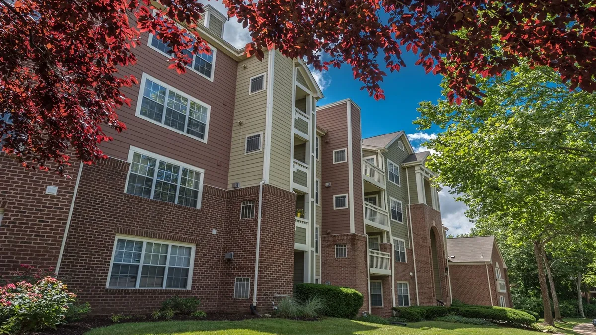 Four-story apartments with brick and brown and tan siding.