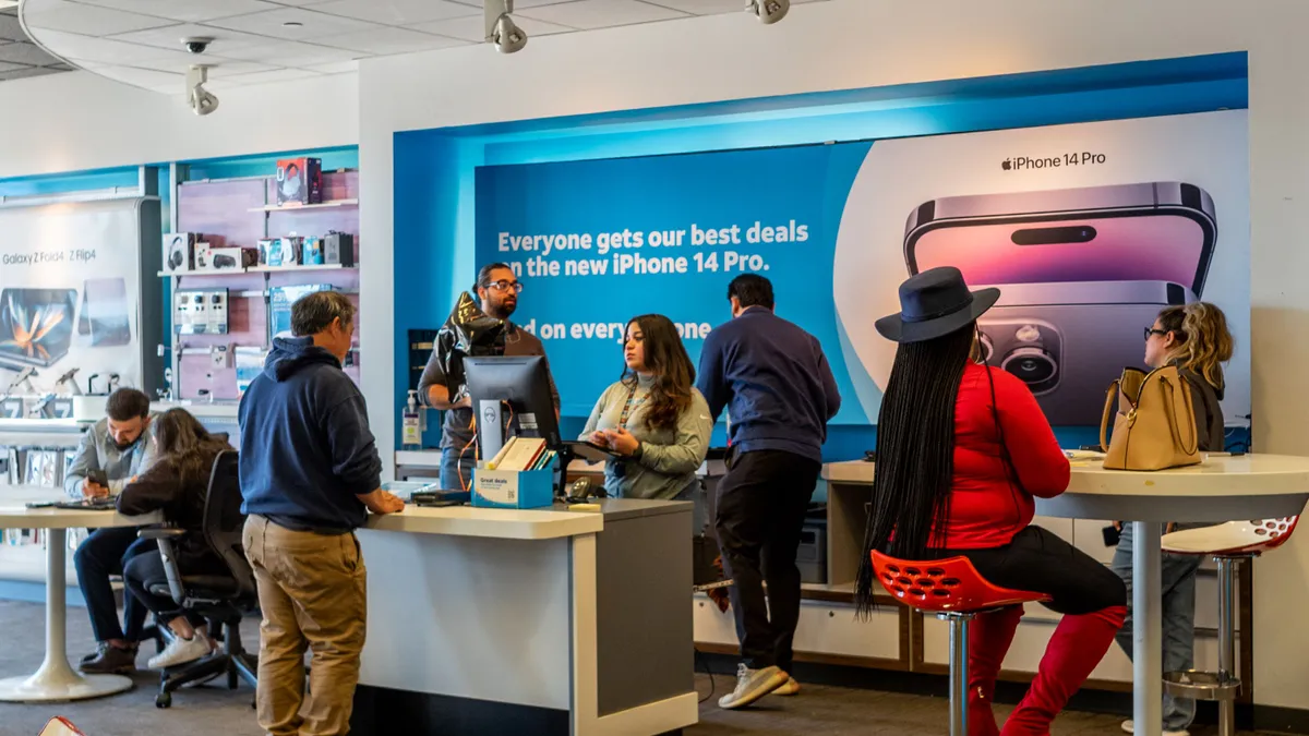 Customers speak with employees in a store.