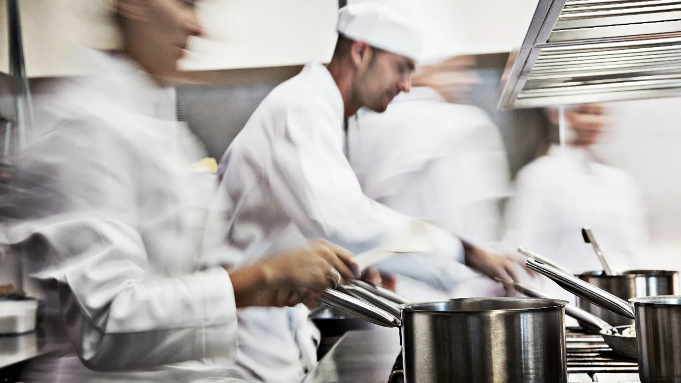 A photograph of chefs in a kitchen.