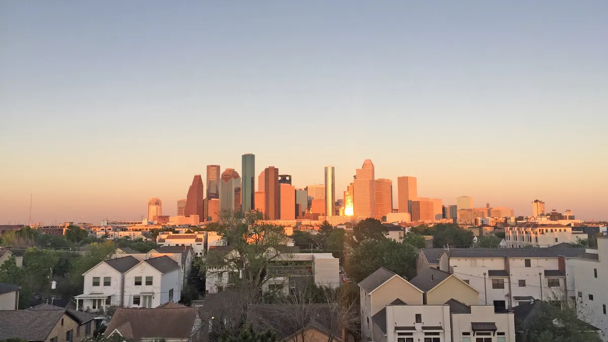 View of downtown Houston during sunset on a clear day with townhouses on the foreground. Viewed from Washington Avenue area.