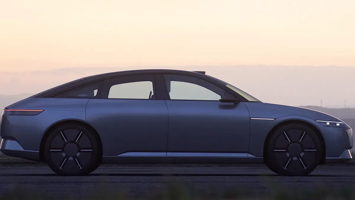 A prototype of the Afeela 1 electric sedan that was unveiled in 2023 shown outdoors with a dark sky in the background,